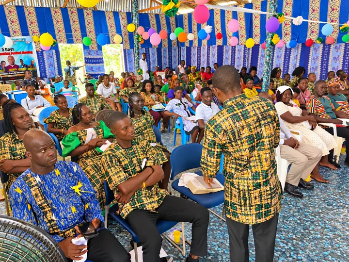 A teacher with an open Bible guiding a congregation