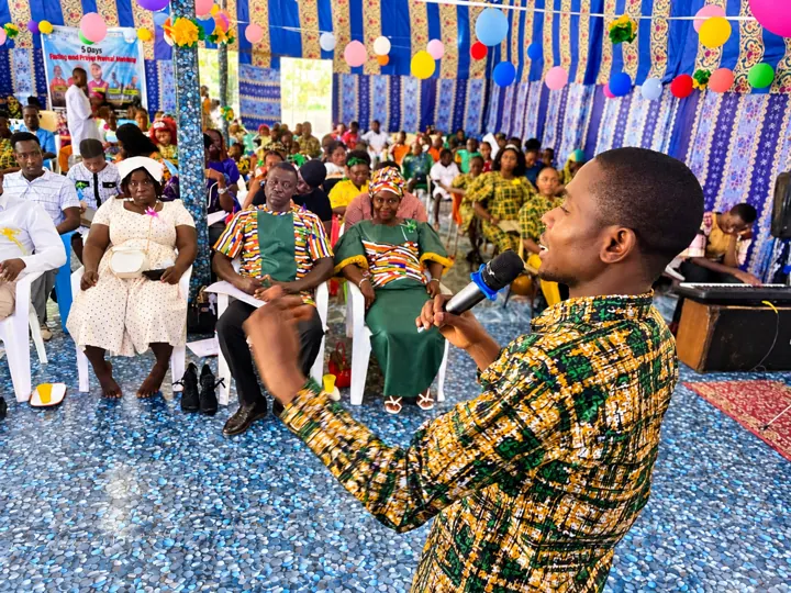 A worship leader singing into a microphone before the congregation